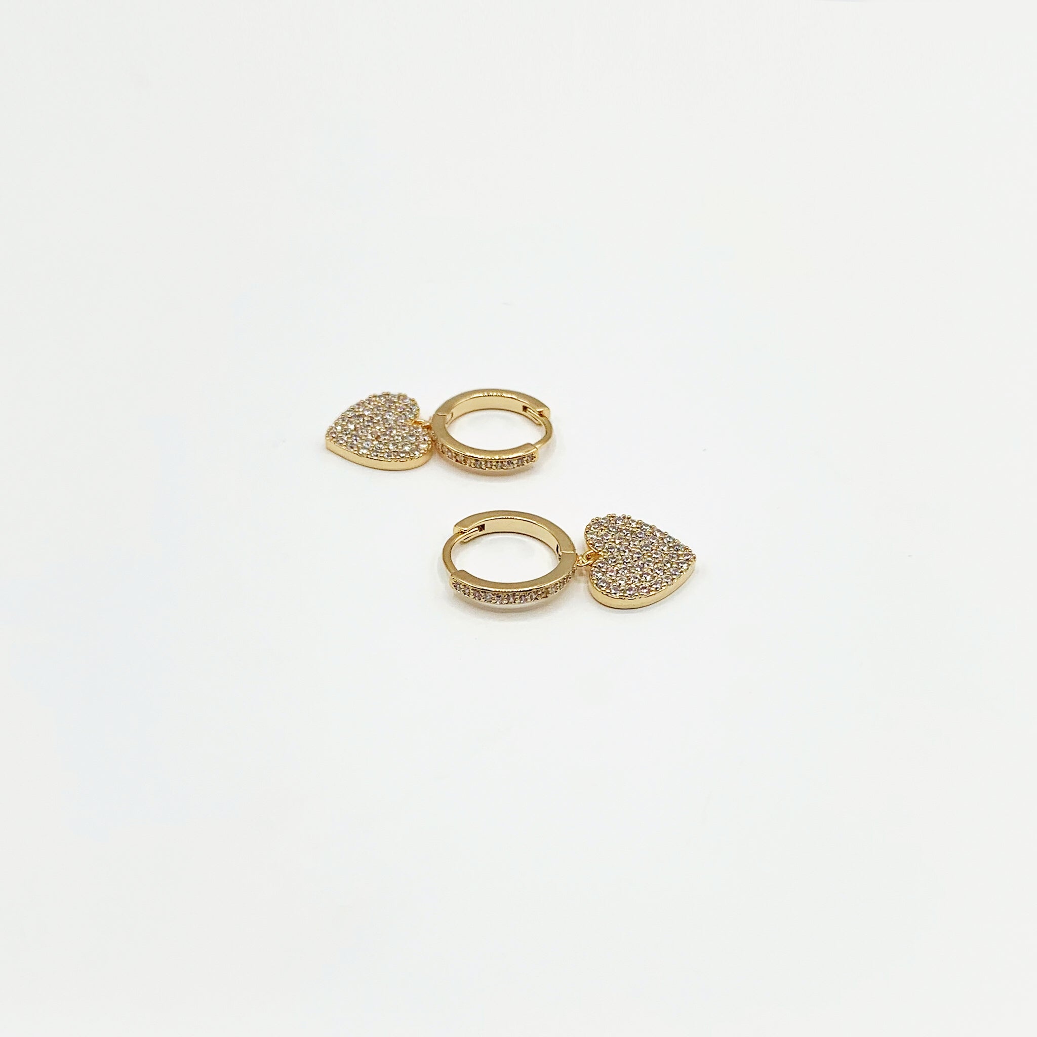 Small gold hoop earrings with drop heart charm paved in diamanté’s 