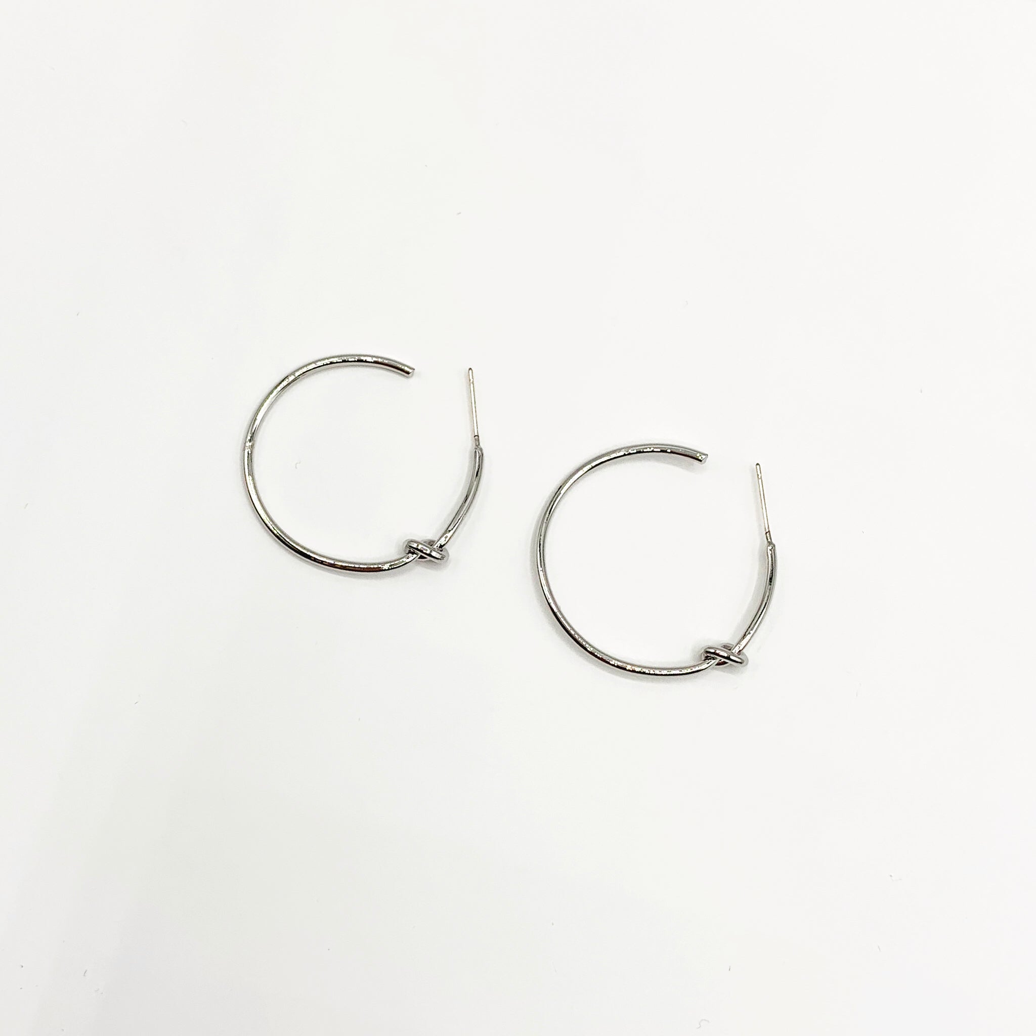 Thin, dainty silver hoops with knot detail