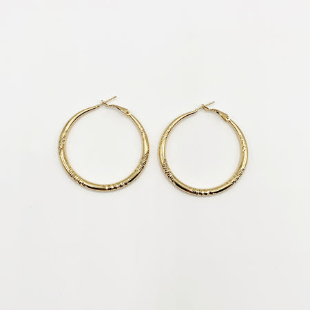 Large gold hoop earrings with delicate etching