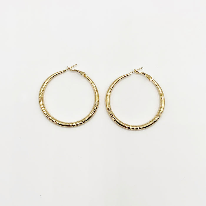 Large gold hoop earrings with delicate etching